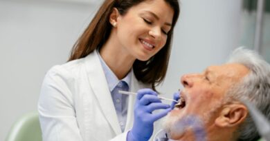 Dentista realizando atendimento em paciente idoso em consultório odontológico, representando a profissão e informações sobre quanto ganha um dentista na Espanha.