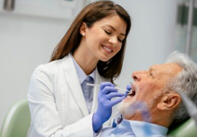 Dentista realizando atendimento em paciente idoso em consultório odontológico, representando a profissão e informações sobre quanto ganha um dentista na Espanha.
